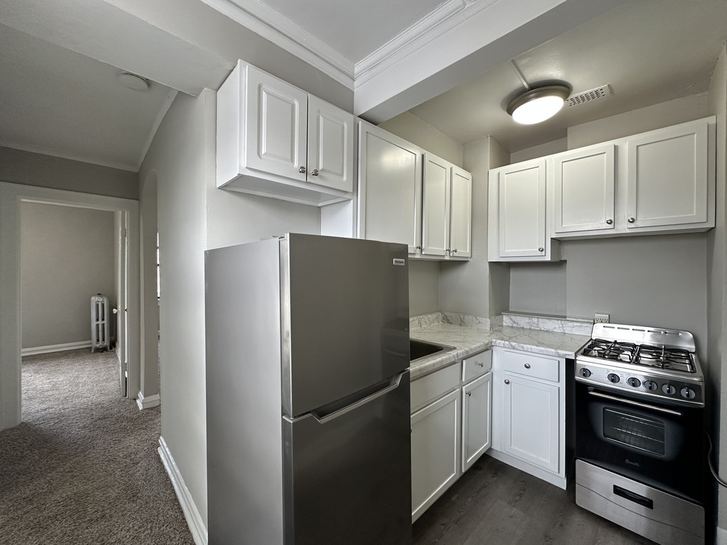 661 West Sheridan Road, Unit 601 Chicago, IL 60613 - Photo 2 of 20 a kitchen with a refrigerator sink and cabinets