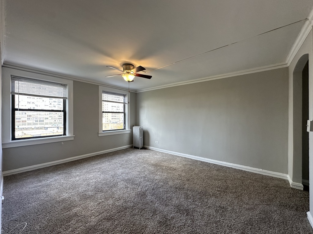 661 West Sheridan Road, Unit 601 Chicago, IL 60613 - Photo 8 of 20 an empty room with windows and chandelier fan