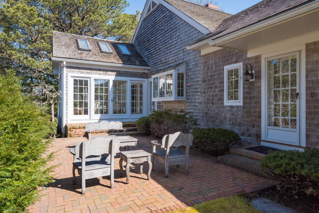 100 Ice Valley Road Osterville, MA 02655 - Photo 18 of 22 a view of a patio with table and chairs and potted plants