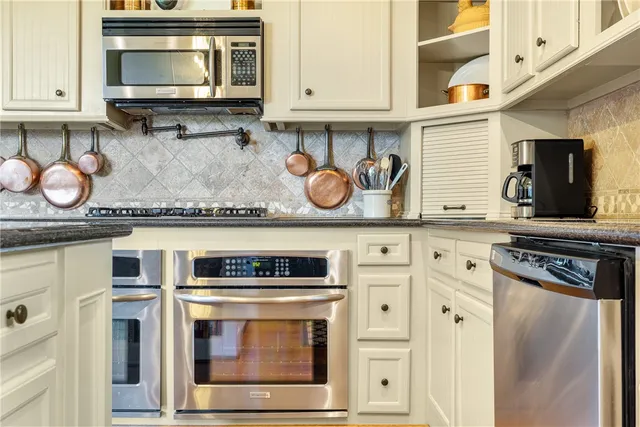 a kitchen with stainless steel appliances granite countertop a stove and a microwave