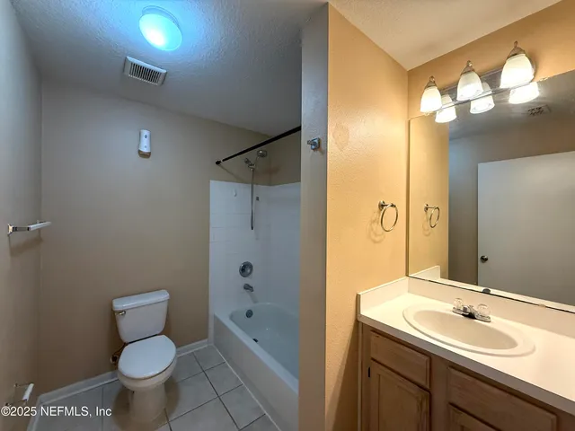 a bathroom with a sink a toilet a mirror a vanity and shower