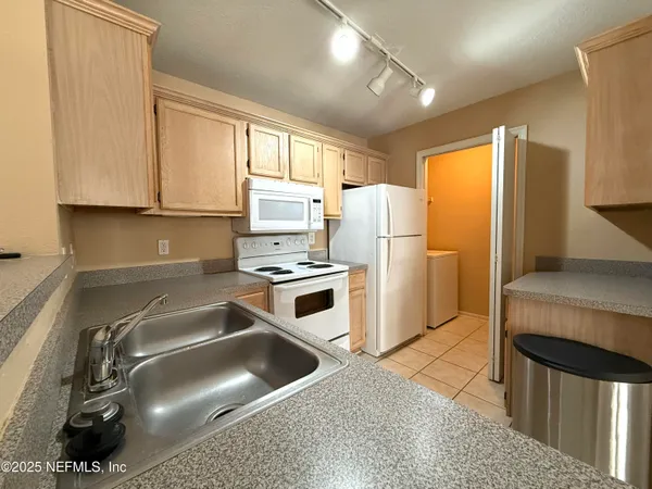 a kitchen with a refrigerator a stove a sink and a cabinets