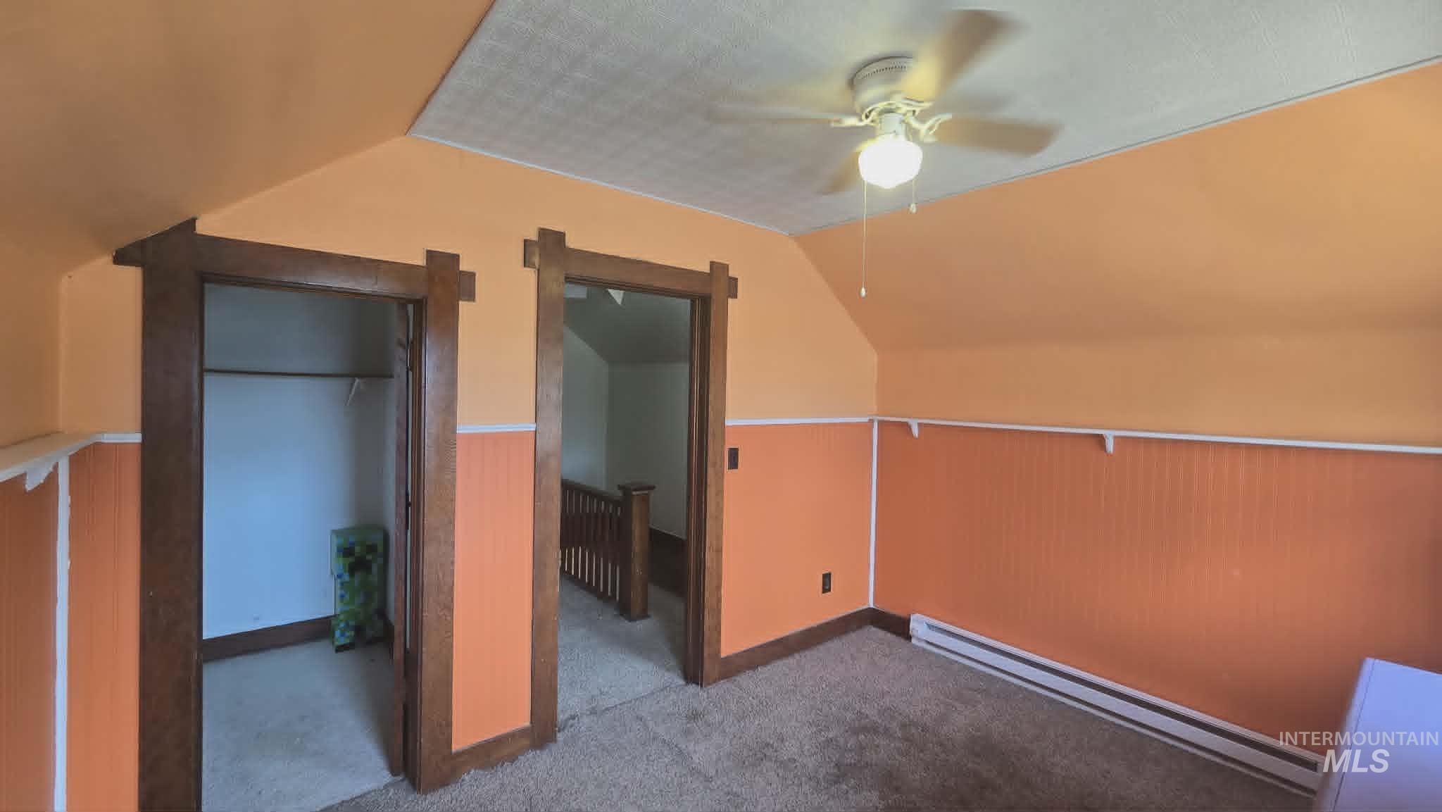 1212 Main Street Pomeroy, WA 99347 - Photo 16 of 18 Carpeted room featuring an angled ceiling, a ceiling fan with light fixture, and wood trim around doorways