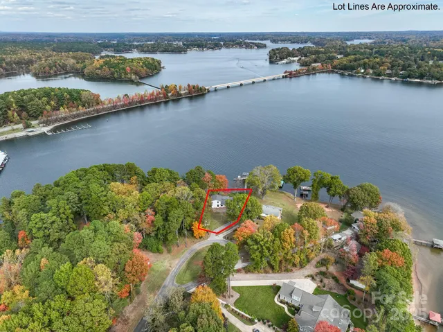 an aerial view of residential houses with outdoor space and lake view