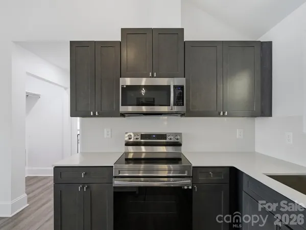 a open kitchen with a table chairs and wooden floors