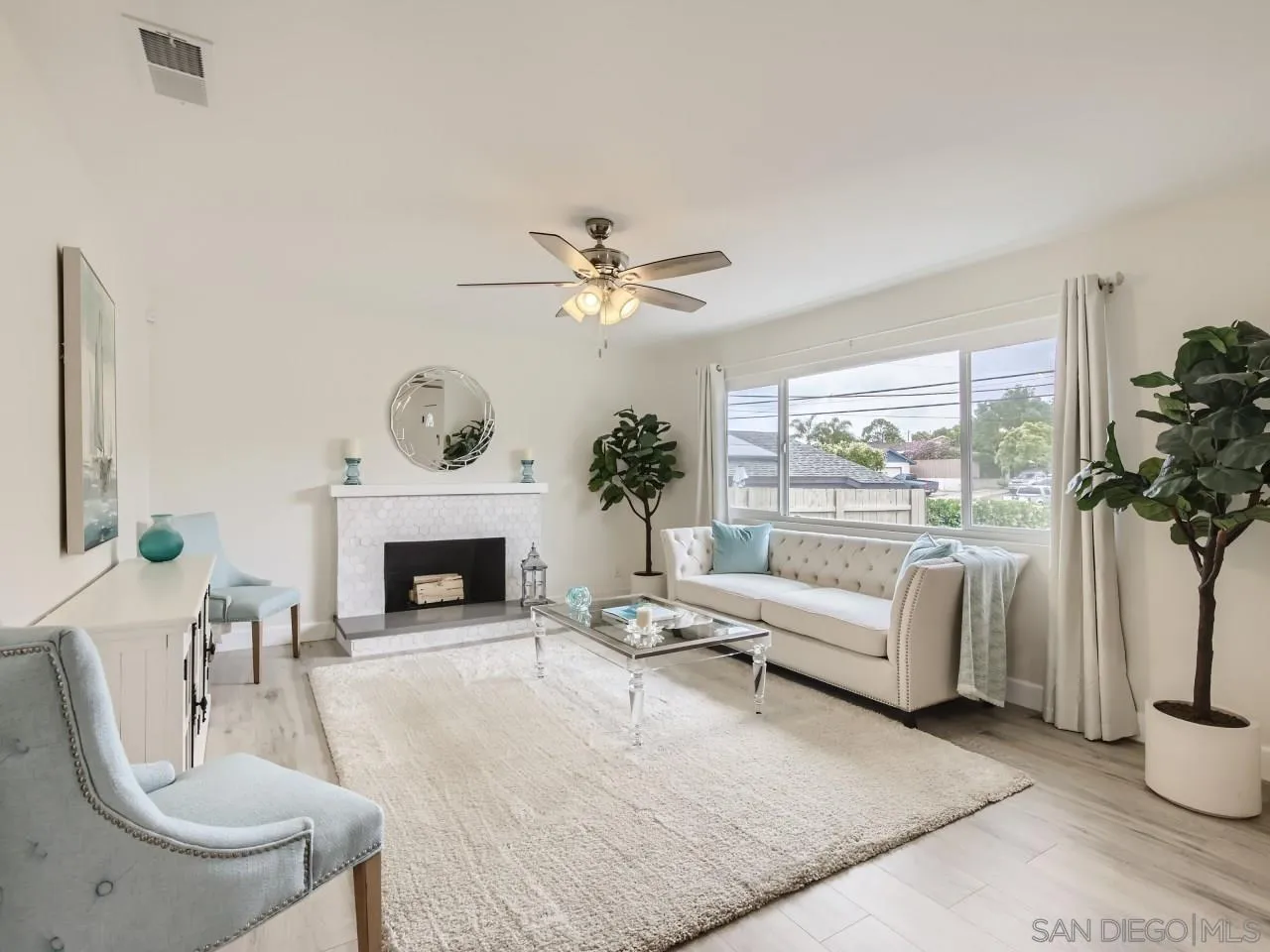 2902 Thunder Drive Oceanside, CA 92056 - Photo 6 of 30 a living room with furniture a fireplace and a large mirror with potted plants