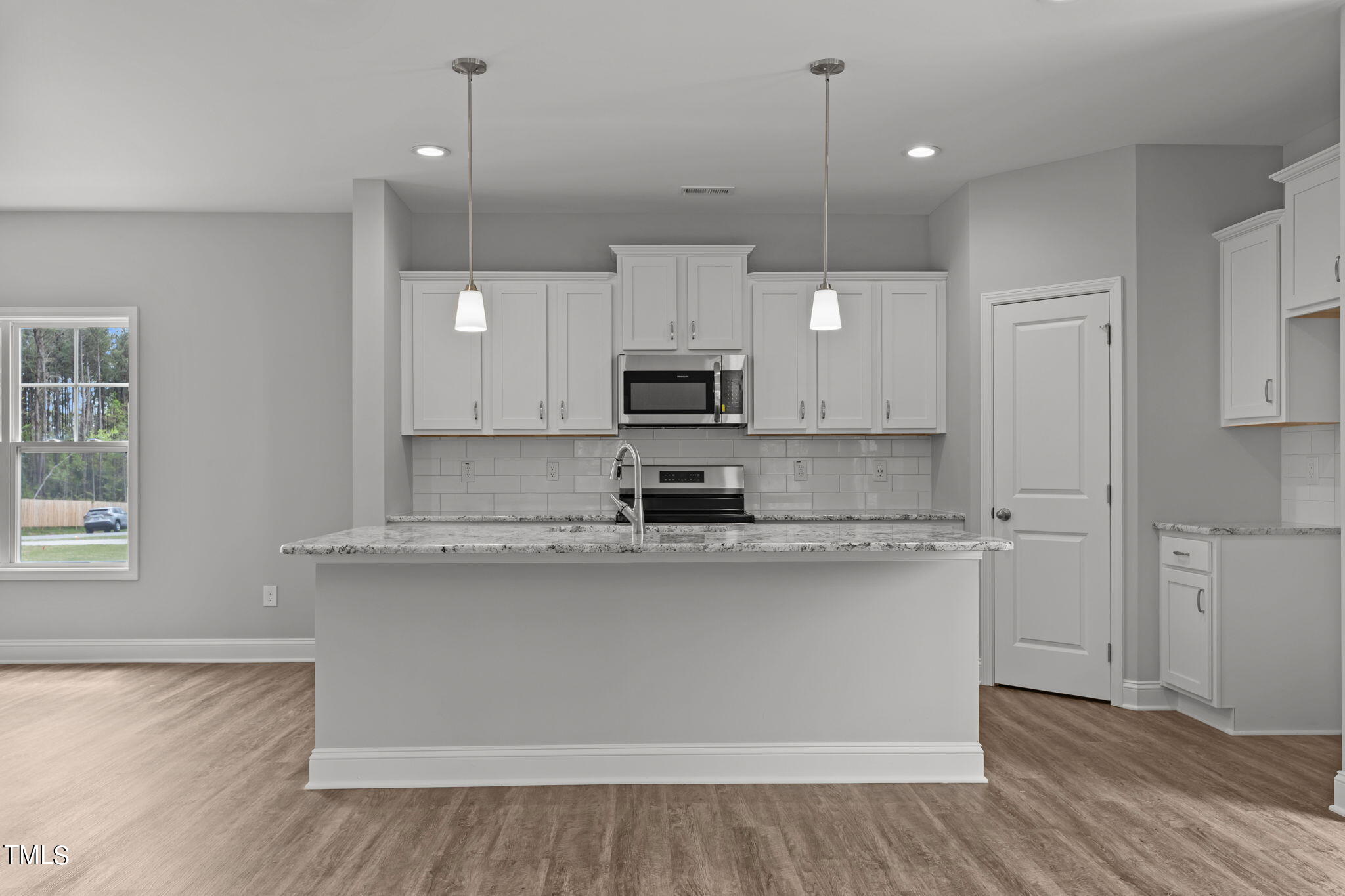 161 Regis Lane Coats, NC 27521 - Photo 11 of 38 a large kitchen with granite countertop a stove a sink a refrigerator and a wooden floor