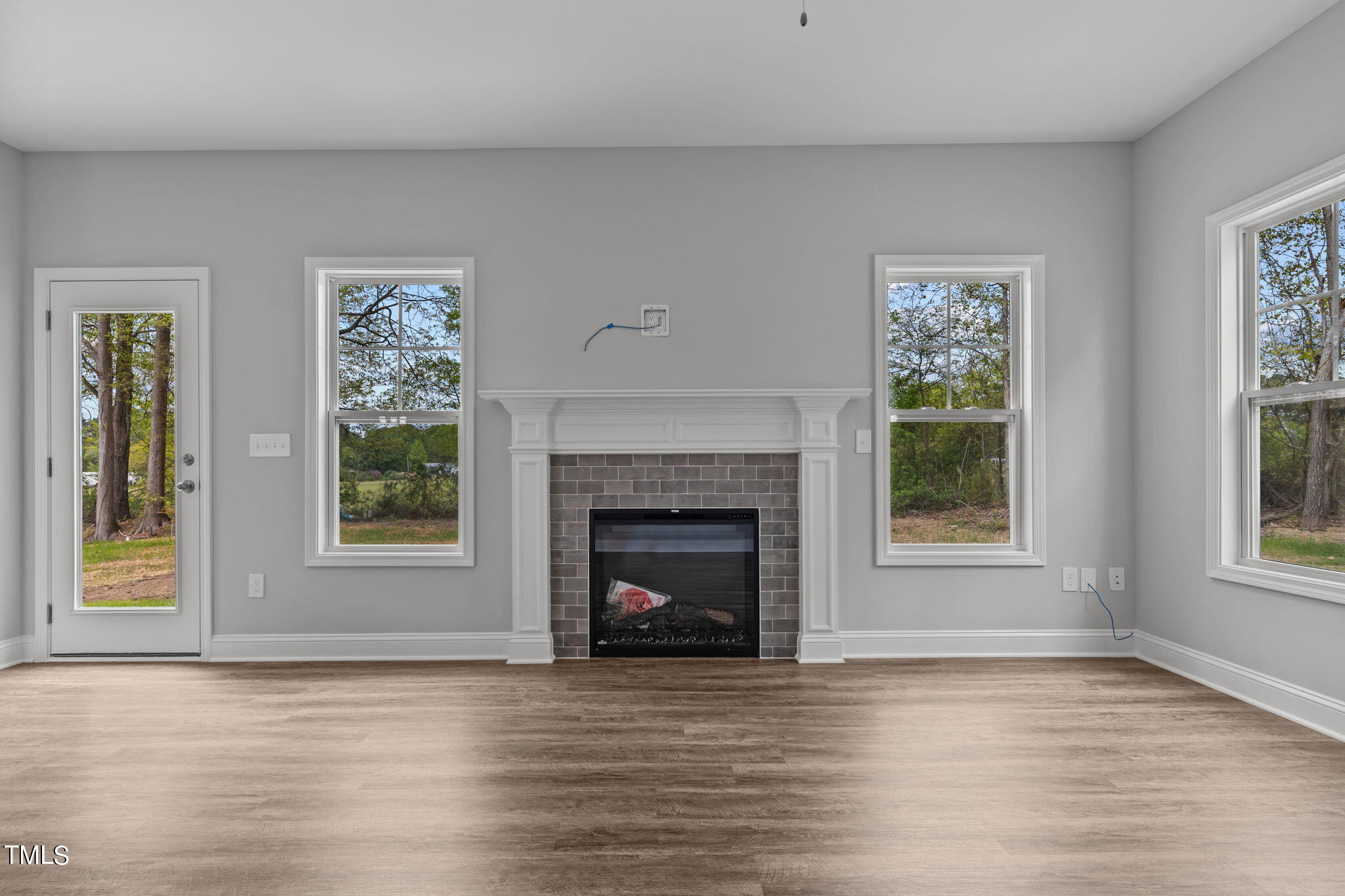 161 Regis Lane Coats, NC 27521 - Photo 9 of 38 a view of an empty room with wooden floor and a fireplace
