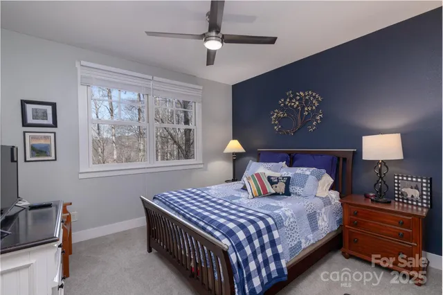 a bedroom with a bed and a lamp on dresser