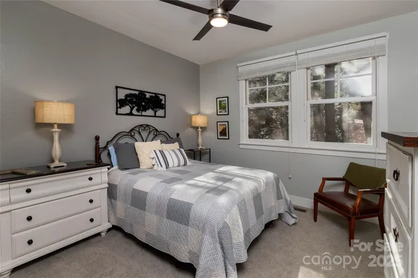 a bedroom with bed and window with chair