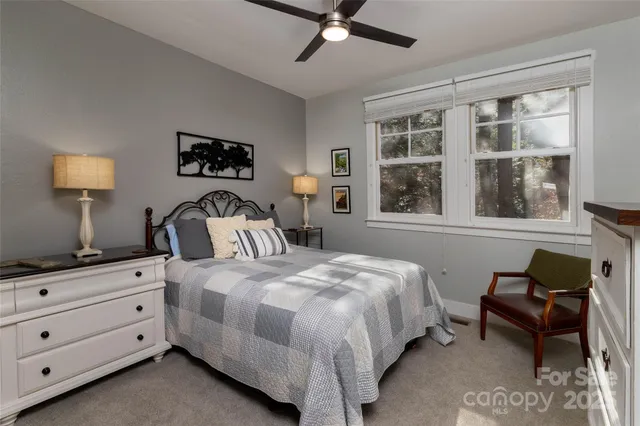 a bedroom with bed and window with chair