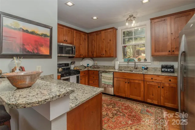 a kitchen with stainless steel appliances granite countertop a sink stove and cabinets