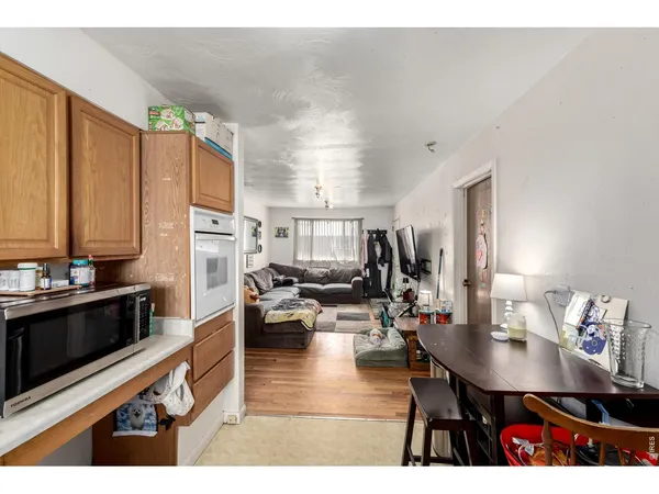 a living room with stainless steel appliances kitchen island granite countertop furniture a rug and a view of kitchen