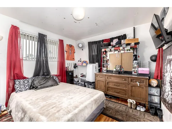 a bedroom with a bed and a flat tv screen