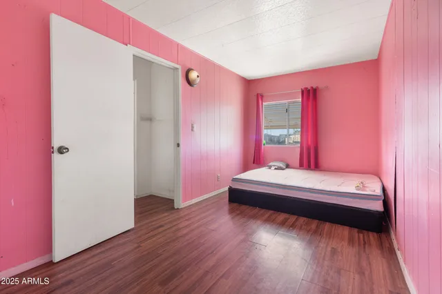 a spacious bedroom with a bed and a wooden floor