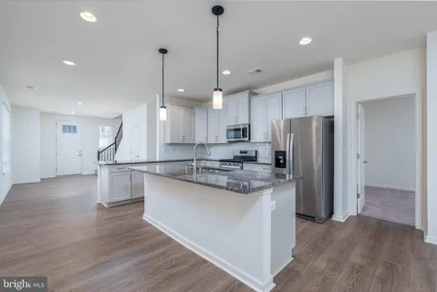 a kitchen with kitchen island white cabinets and stainless steel appliances