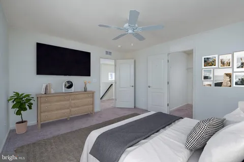 a spacious bedroom with a bed and a flat screen tv