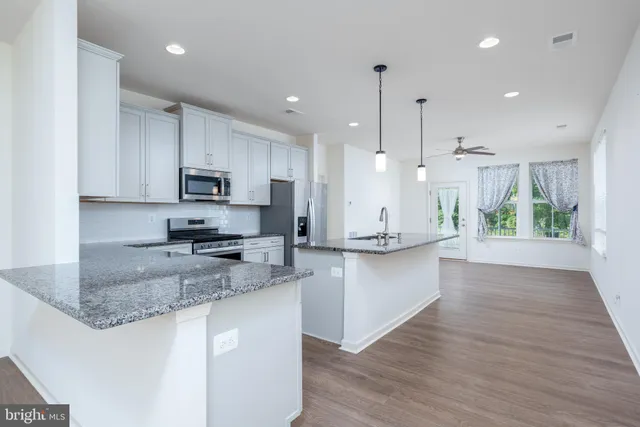 a large kitchen with kitchen island lots of counter space a sink appliances and cabinets