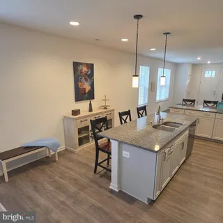 a kitchen with a sink cabinets and wooden floor