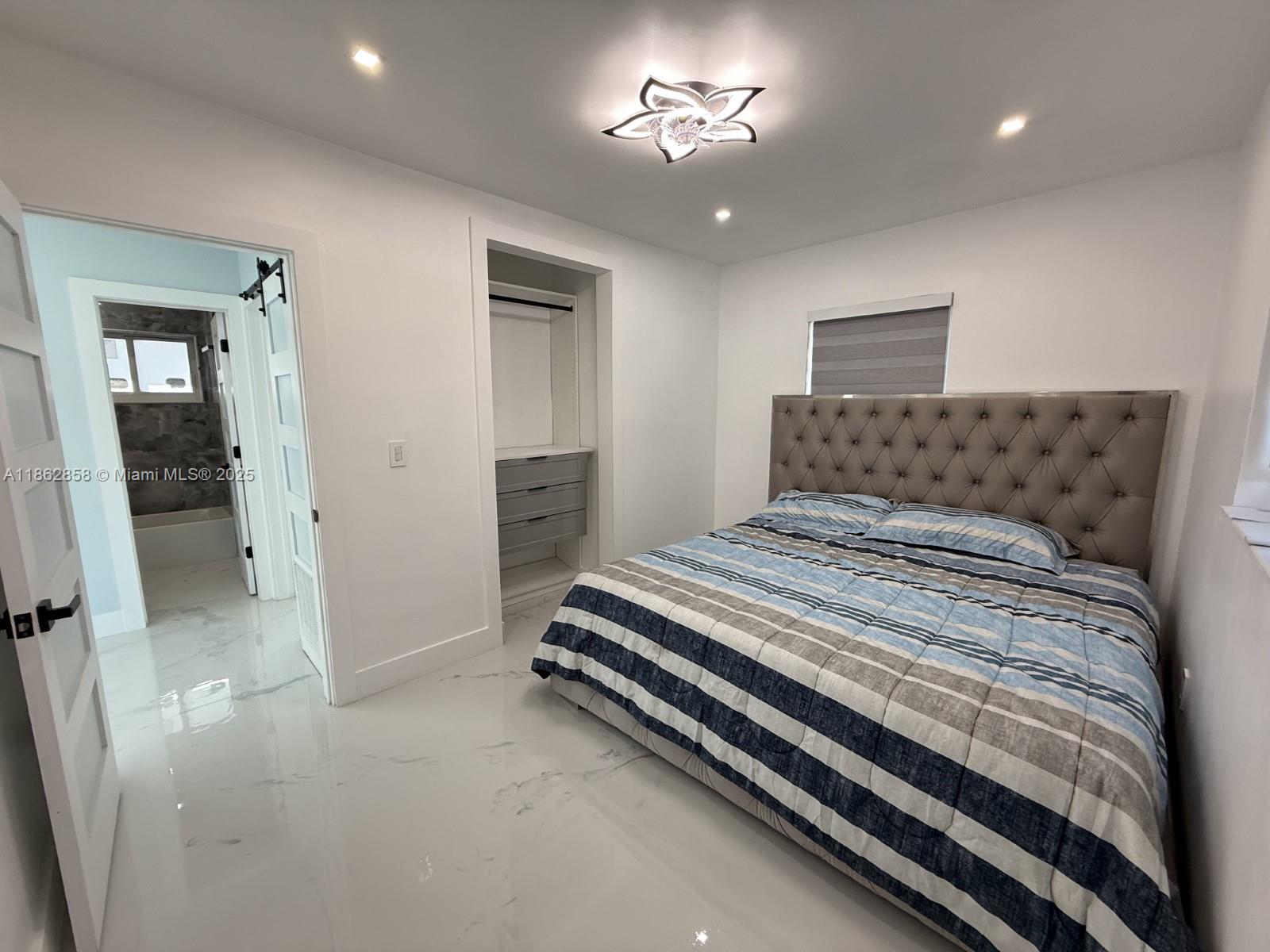 11805 Southwest 185th Street Miami, FL 33177 - Photo 12 of 28 a bedroom with a bed and a chandelier