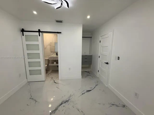 a kitchen with kitchen island a counter top space cabinets and stainless steel appliances