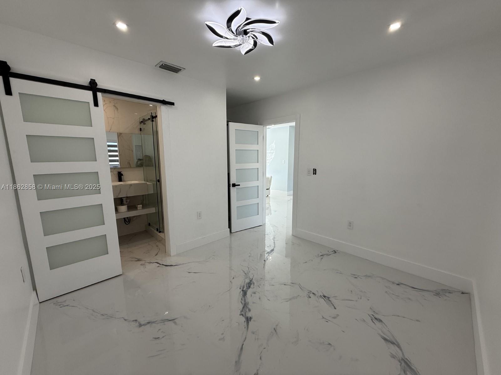 11805 Southwest 185th Street Miami, FL 33177 - Photo 18 of 28 a view of an empty room with a ceiling fan