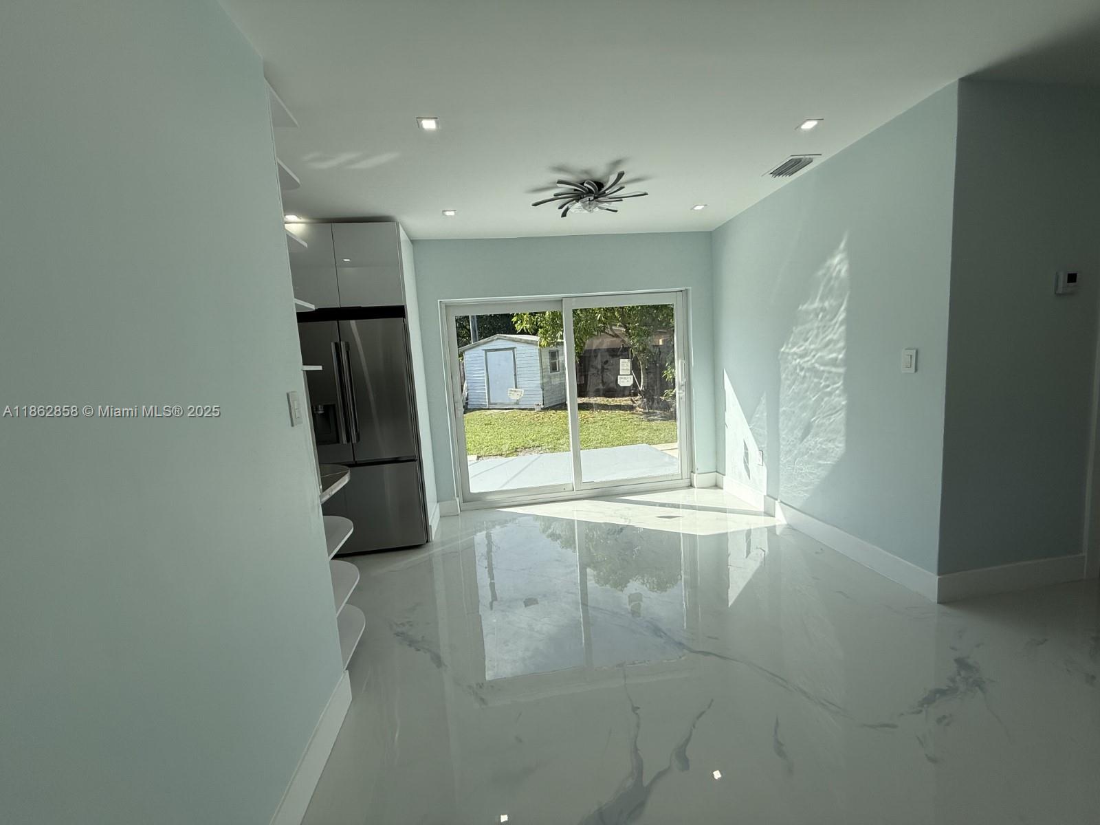 11805 Southwest 185th Street Miami, FL 33177 - Photo 21 of 28 en empty room with glass door and chandelier