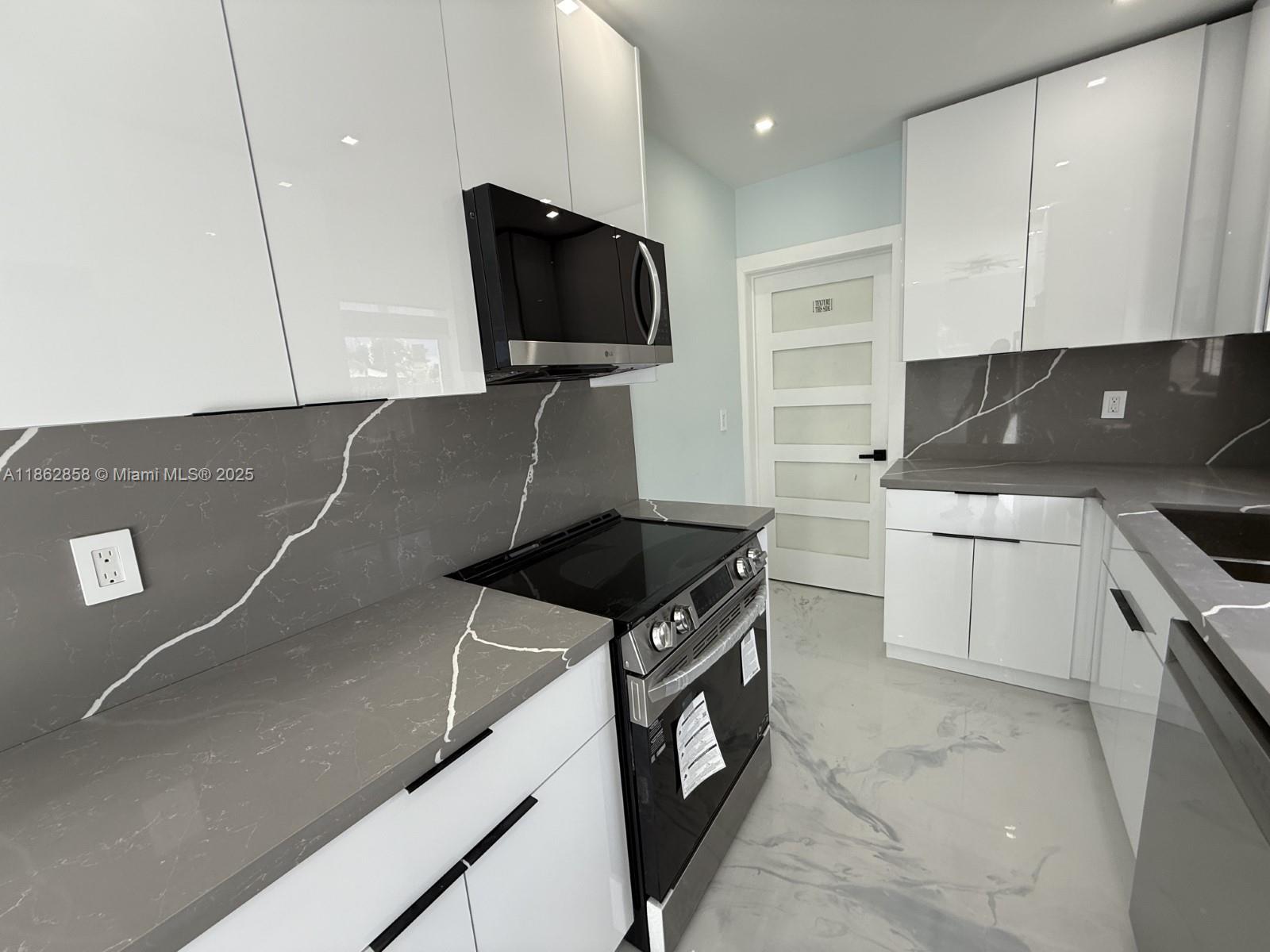11805 Southwest 185th Street Miami, FL 33177 - Photo 10 of 28 a kitchen with a sink a stove and microwave