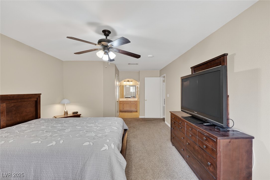 698 South Racetrack Road, Unit 1222 Henderson, NV 89015 - Photo 16 of 31 Bedroom with light carpet, ceiling fan, and ensuite bathroom