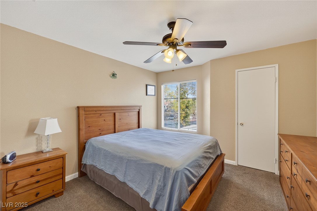 698 South Racetrack Road, Unit 1222 Henderson, NV 89015 - Photo 21 of 31 Bedroom with dark carpet and ceiling fan