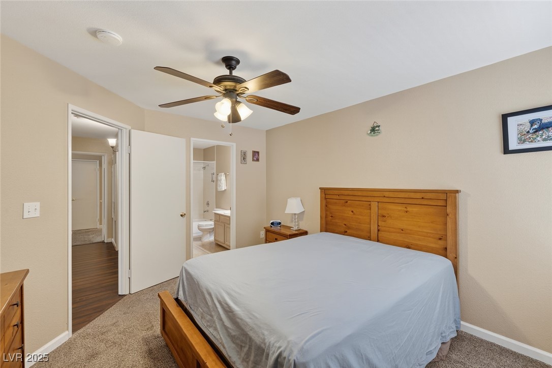 698 South Racetrack Road, Unit 1222 Henderson, NV 89015 - Photo 22 of 31 Bedroom featuring light colored carpet, ensuite bathroom, and ceiling fan