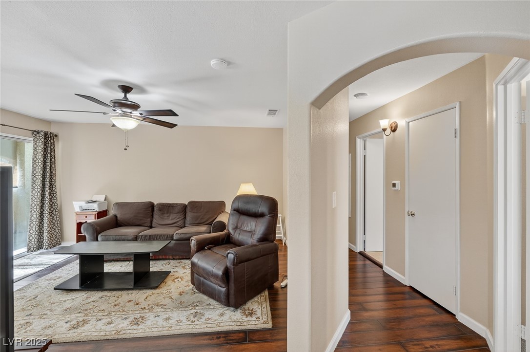 698 South Racetrack Road, Unit 1222 Henderson, NV 89015 - Photo 3 of 31 Living area featuring arched walkways, dark wood-style flooring, and ceiling fan