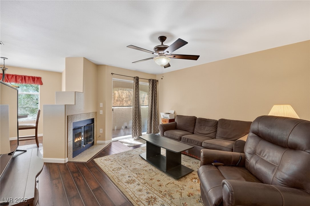 698 South Racetrack Road, Unit 1222 Henderson, NV 89015 - Photo 4 of 31 Living area with hardwood / wood-style flooring, a fireplace, and a ceiling fan
