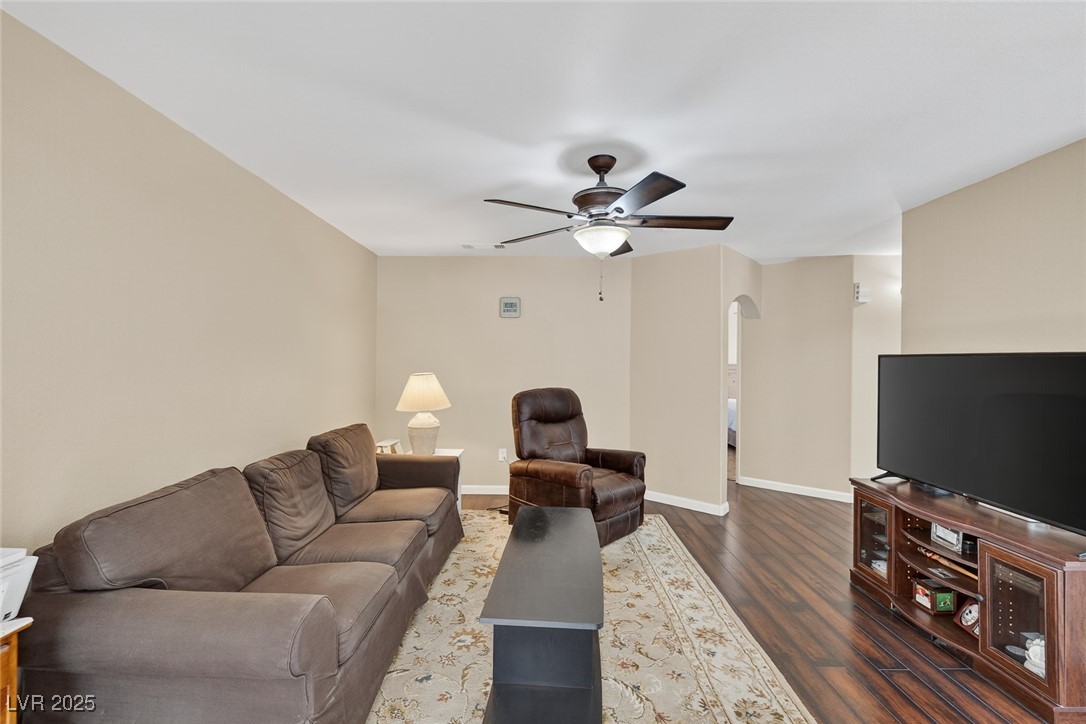 698 South Racetrack Road, Unit 1222 Henderson, NV 89015 - Photo 7 of 31 Living room featuring arched walkways, dark wood-type flooring, and a ceiling fan