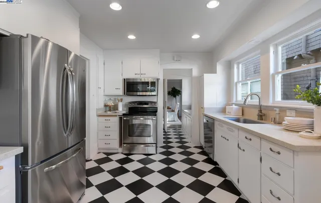 a kitchen with stainless steel appliances a refrigerator sink and microwave