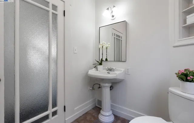 a bathroom with a sink a mirror and toilet