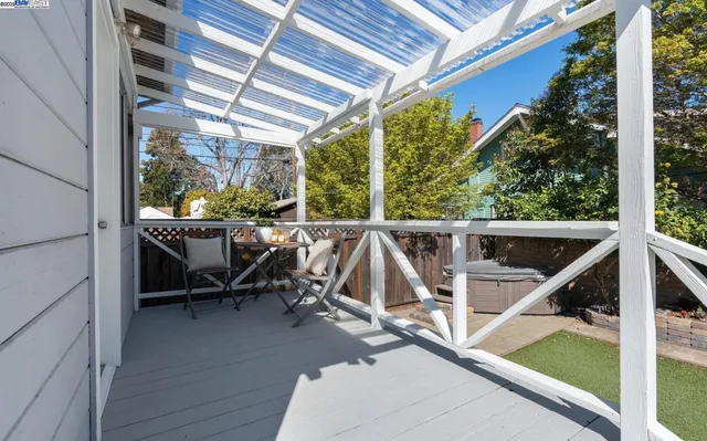 a view of house with wooden deck and furniture