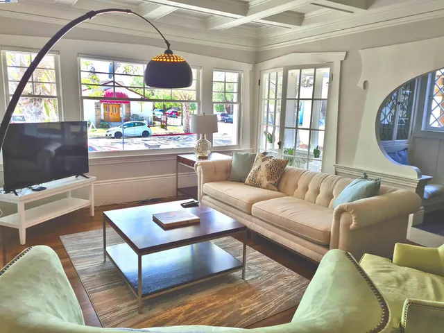 a living room with furniture a window and a flat screen tv