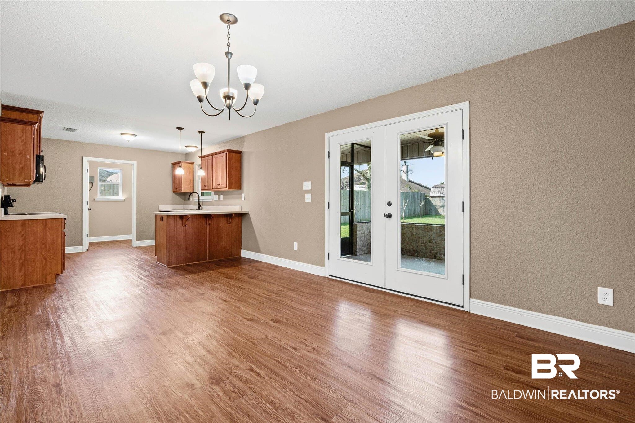101 Washington Boulevard Foley, AL 36535 - Photo 6 of 32 Unfurnished dining area with light wood-type flooring, french doors, hanging lights, and a textured wall