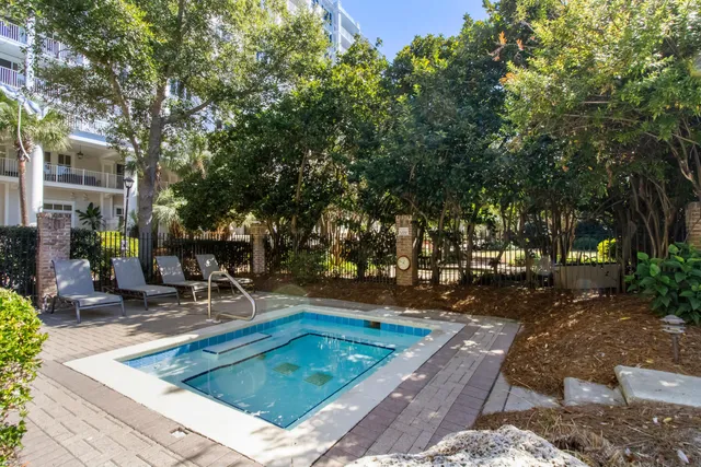 a view of a swimming pool with lawn chairs under an umbrella