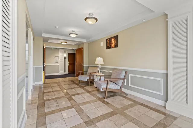 a view of a hallway with a dining table and chairs