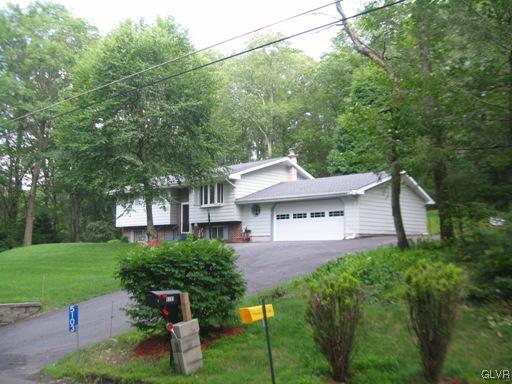 5103 High Terrace Road Stroudsburg, PA 18360 - Photo 1 of 20 a front view of a house with a yard and fountain in middle
