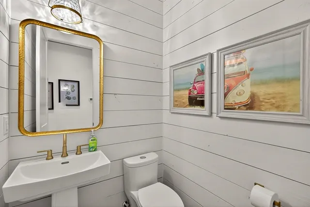 a bathroom with a toilet sink and mirror