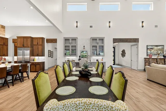 a living room with furniture a fireplace and a dining table with wooden floor