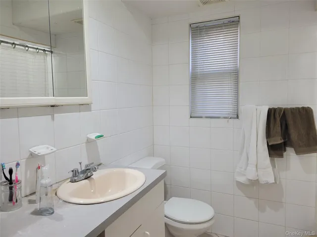 a bathroom with a sink vanity mirror and toilet