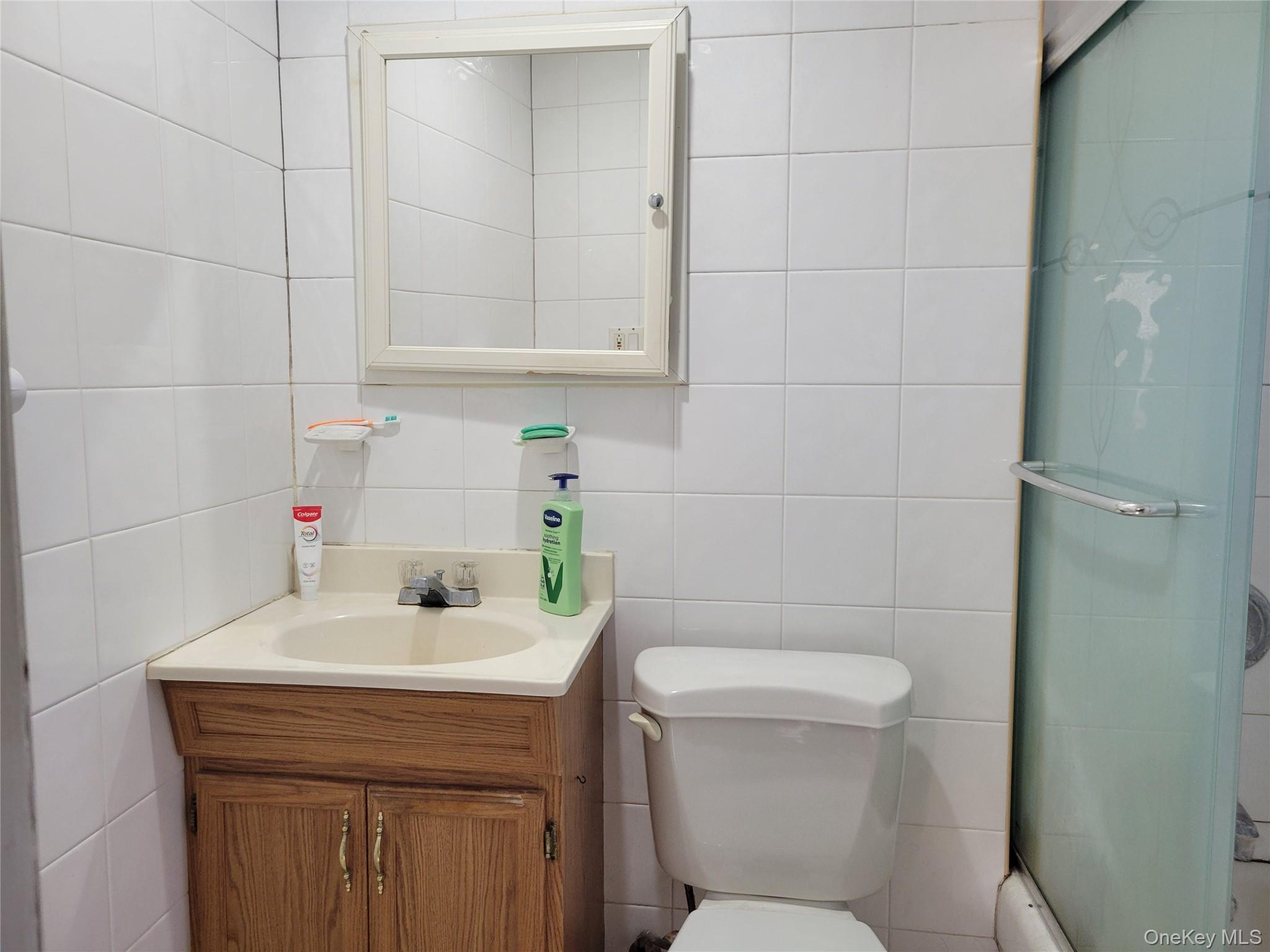 16-49 200th Street Queens, NY 11360 - Photo 8 of 8 a bathroom with a sink a toilet and vanity