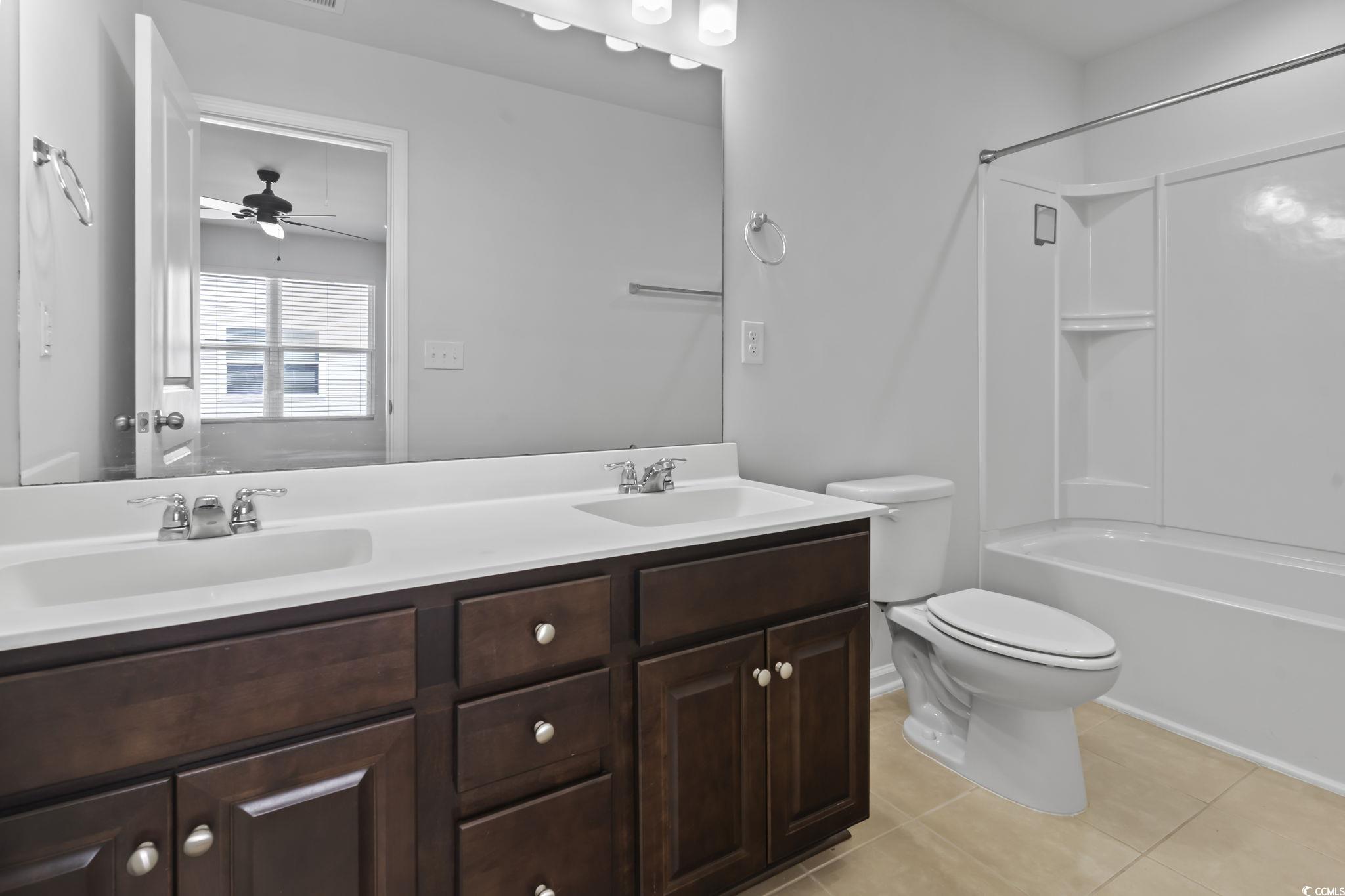 301 Castle Drive, Unit 301 Myrtle Beach, SC 29579 - Photo 20 of 30 Full bathroom featuring ceiling fan, vanity, tile