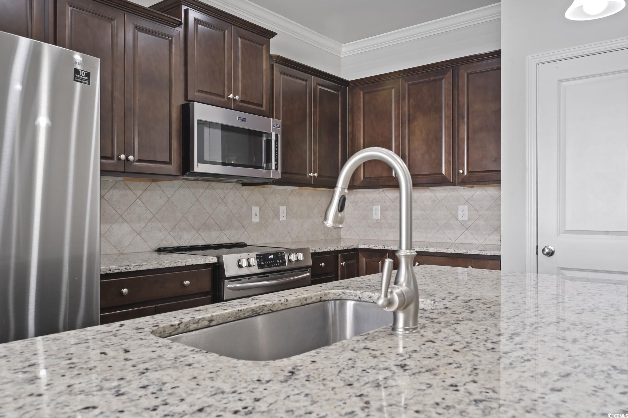 301 Castle Drive, Unit 301 Myrtle Beach, SC 29579 - Photo 2 of 30 Kitchen with light stone countertops, ornamental m