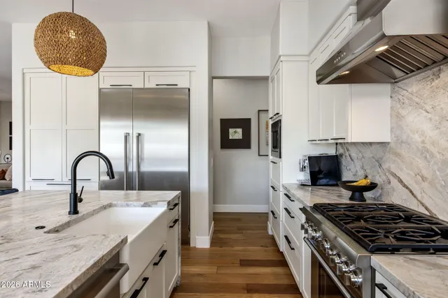 a kitchen with granite countertop a stove a sink and a stove