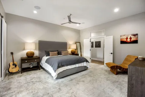 a spacious bedroom with a bed and a chandelier